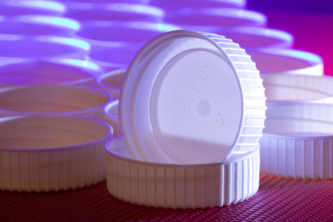 Aesthetic arrangement of white plastic lids with striking blue and purple lighting.